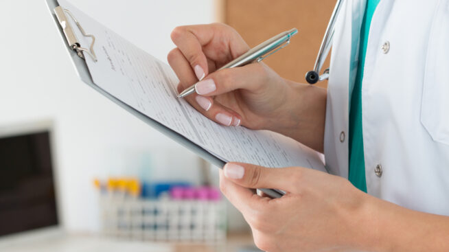 Female hand filling out a form in a blood laboratory.